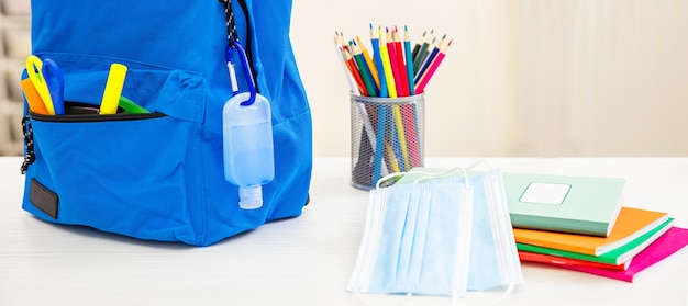 Journées du coronavirus à l'école COVID 19 protecton gel désinfectant pour les mains et sac à dos sur le bureau de l'élève