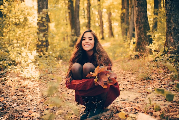 Joyeuse belle fille en pull rouge à l'extérieur le beau jour d'automne fille heureuse sur copie de marche d'automne...