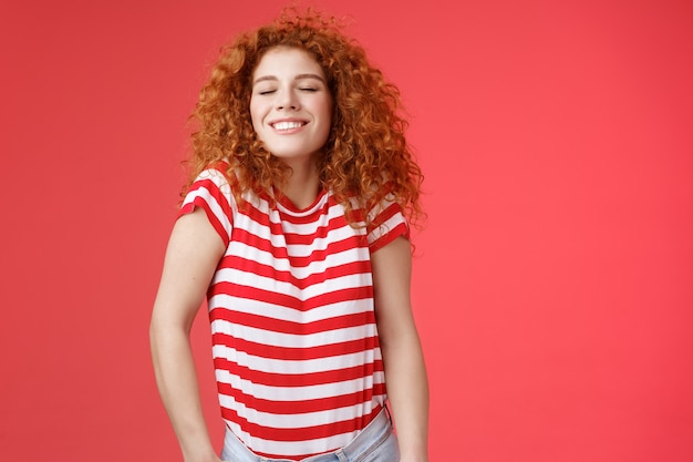 Joyeuse détendue insouciante heureuse rousse séduisante femme bouclée fermer les yeux profiter de la lumière du soleil été chaud...