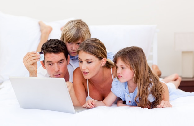 Joyeuse famille d&#39;achat en ligne couchée sur le lit