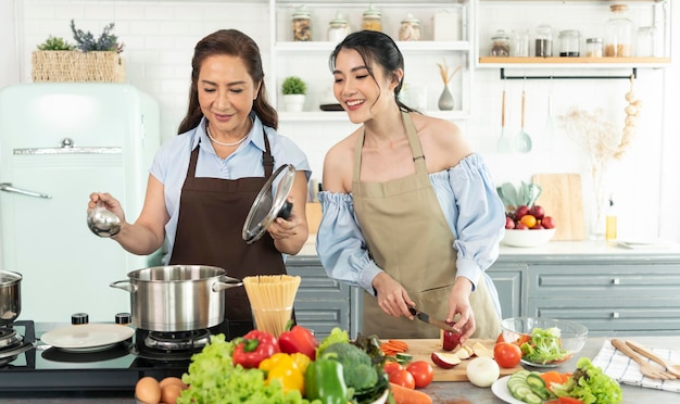 Joyeuse famille asiatique cuisinant des aliments dans la cuisine à la maison Profitez d'une activité familiale ensemble