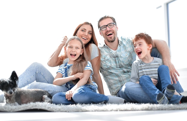 Joyeuse famille assise sur le tapis dans le nouveau salon