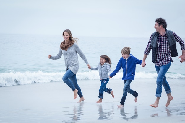 Joyeuse famille en cours d'exécution au bord de la mer