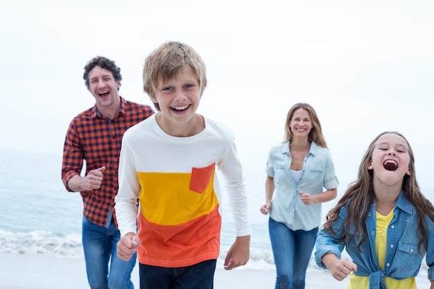 Joyeuse famille en cours d'exécution à la plage