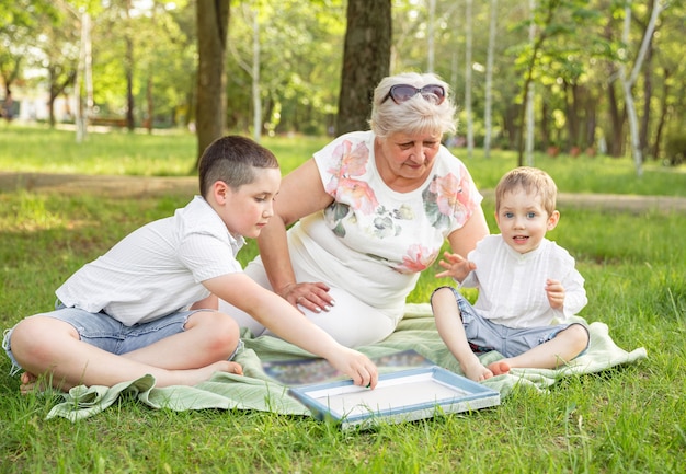 Joyeuse famille élargie jouant au jeu de société dans leur jardin.