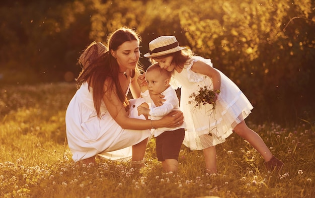 Joyeuse famille de mère petit fils et fille passant du temps libre sur le terrain aux beaux jours de l'été