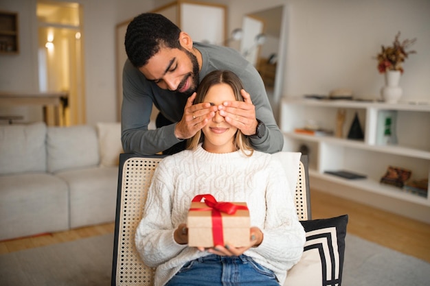 Joyeuse famille millénaire multiethnique célébrant l'anniversaire de l'anniversaire de son mari ferme les yeux à sa femme