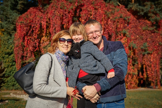 Joyeuse famille se promène dans le parc d'automne