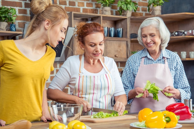 Joyeuse famille de trois générations cuisinant ensemble dans la cuisine