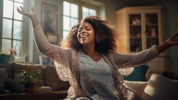 Une joyeuse femme afro-américaine dansant sur son canapé