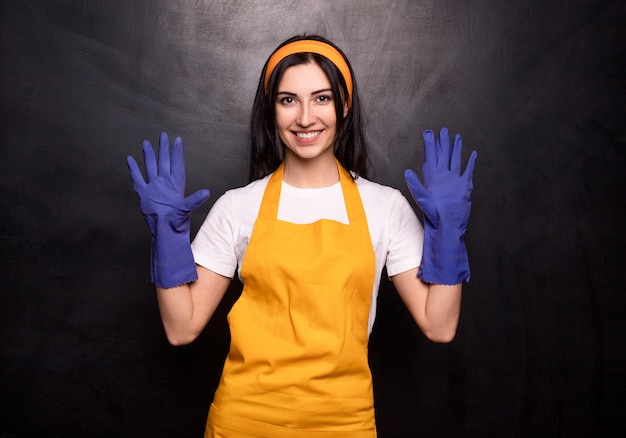 Joyeuse femme au foyer en tablier et gants