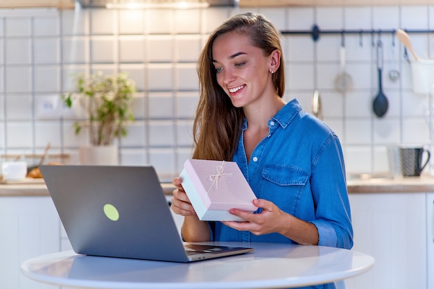 Joyeuse Femme Heureuse Souriante Heureuse Reçoit Une Boîte-cadeau Et Bavarde En Ligne