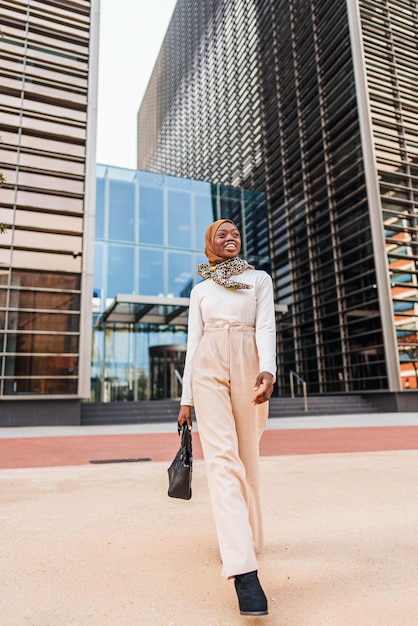 Joyeuse femme noire en hijab dans le centre-ville