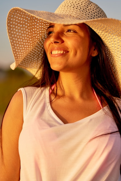 Joyeuse femme rêveuse contemplant le coucher du soleil