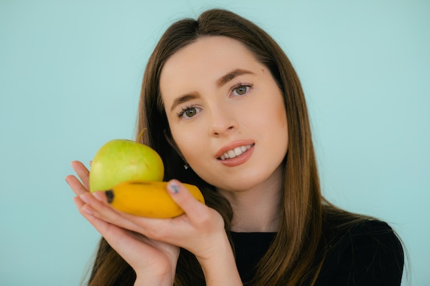 Joyeuse femme souriante tenant une pomme