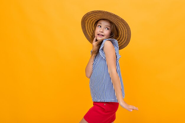 Joyeuse Fille Charmante Dans Un Chapeau De Paille D'été Sur Orange Vif