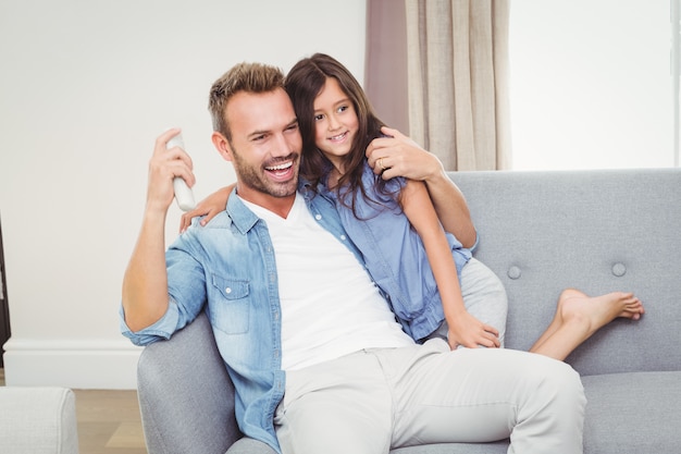 Joyeuse fille et son père devant la télévision