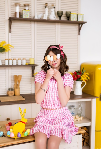 Joyeuse fille souriante avec des oeufs colorés Préparation pour les vacances de Pâques