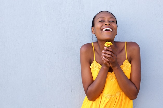 Joyeuse jeune femme africaine tenant une fleur