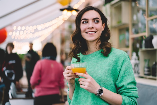 Joyeuse jeune femme debout avec un verre dans une tasse