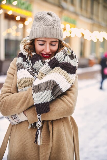 Joyeuse jeune femme profitant du temps neigeux à l'extérieur