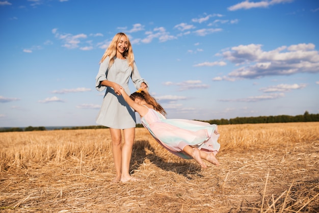 Joyeuse jeune mère dans une robe bleue