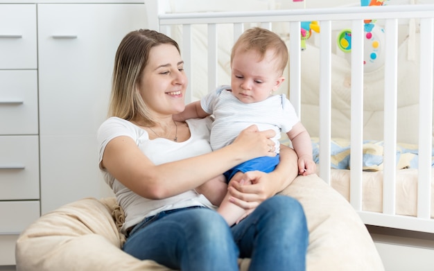 Joyeuse jeune mère lisant un livre à son petit garçon au salon