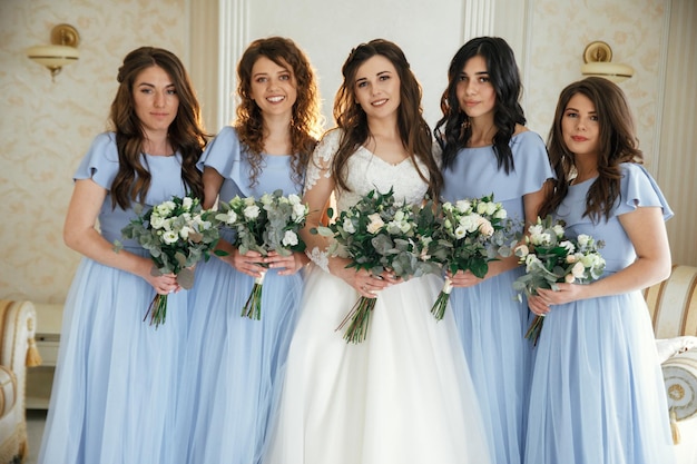 Joyeuse mariée et demoiselles d'honneur avec des bouquets