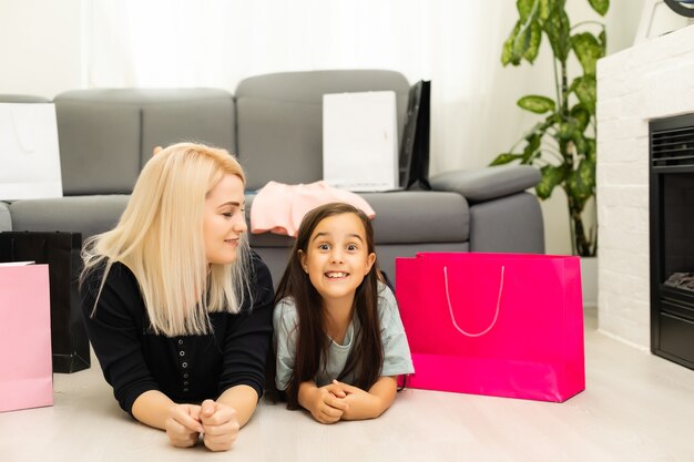 Joyeuse mère et sa fille s'amusant à la maison après le shopping