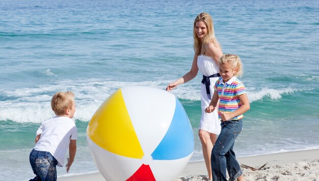 Joyeuse mère et ses enfants jouant avec une balle