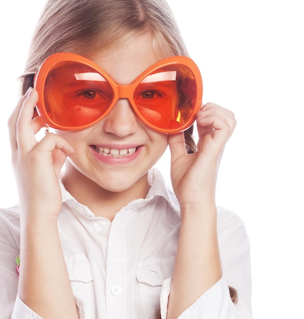 Joyeuse petite fille avec de grosses lunettes orange isolées sur le Whi