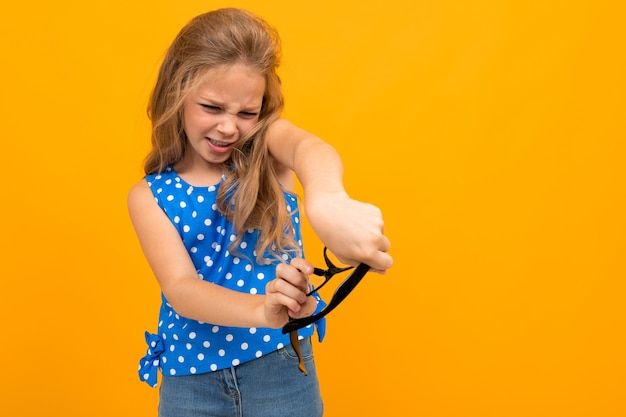 Joyeuse petite fille avec des lunettes noires isolées