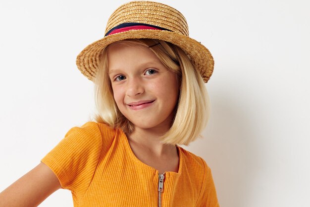 Joyeuse petite fille portant un chapeau fashion posant fond clair