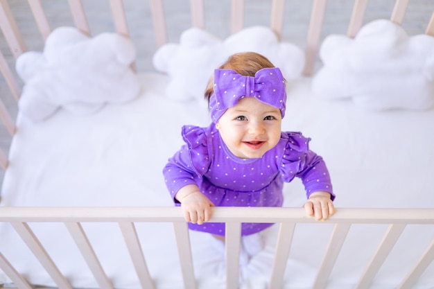 Une joyeuse petite fille de six mois se baigne dans un bain avec de la mousse et des canards en caoutchouc un petit enfant s'amuse à jouer avec de l'eau le concept de soins et d'hygiène