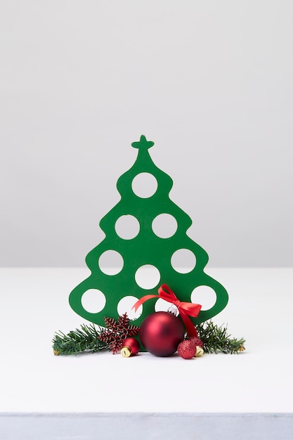 Joyeuses fêtes décorées de boules de Noël et arbre de Noël sur un mur blanc de bureau