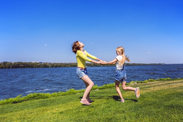 Joyeuses fêtes - Filles sœurs s'amusant dans le pré