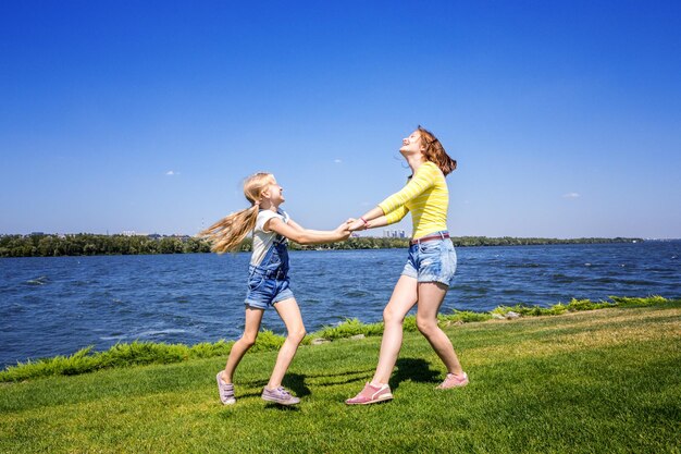 Joyeuses fêtes - Filles sœurs s'amusant dans le pré