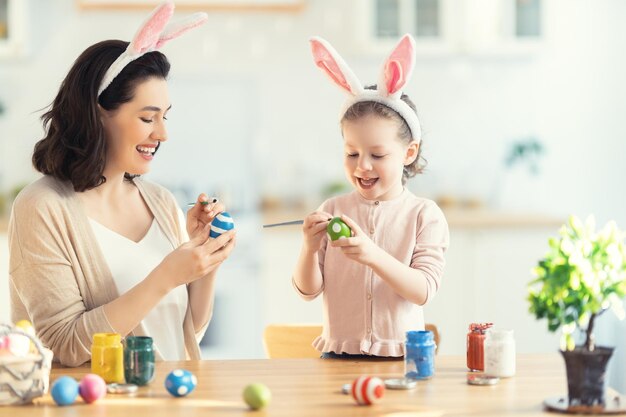 Joyeuses fêtes Une mère et sa fille peignent des œufs Famille se préparant pour Pâques