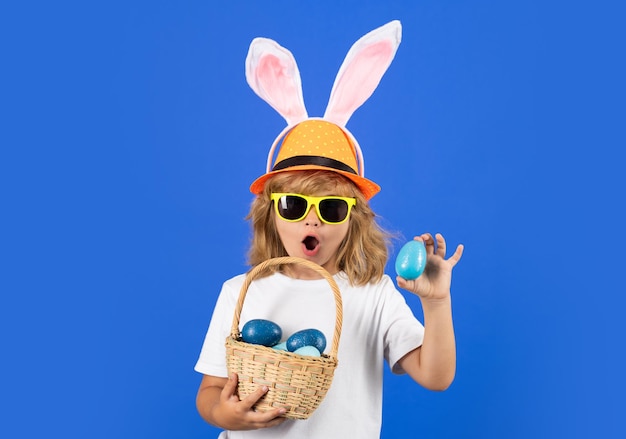 Joyeuses fêtes de Pâques mignon petit enfant portant des oreilles de lapin isolé sur fond bleu
