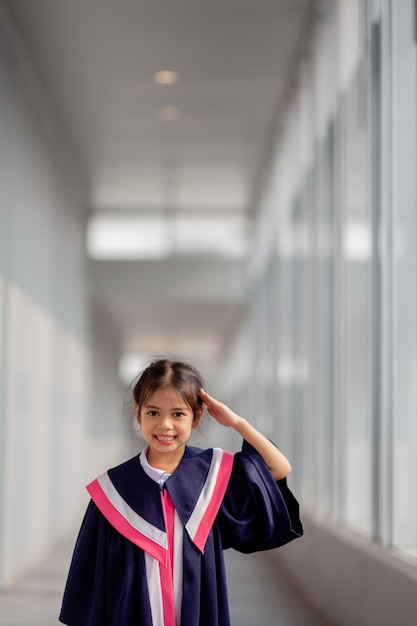 Joyeuses filles asiatiques en robes de graduation le jour de leur remise des diplômes à l'école Concept de graduation avec copie spacex9