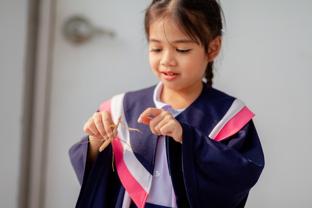 Joyeuses filles asiatiques en robes de graduation le jour de leur remise des diplômes à l'école Concept de graduation avec copie spacex9