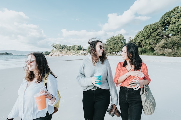 Joyeuses jeunes femmes riant et souriant à la plage un jour d'été, profitant de vacances, concept d'amitié profitant de l'extérieur