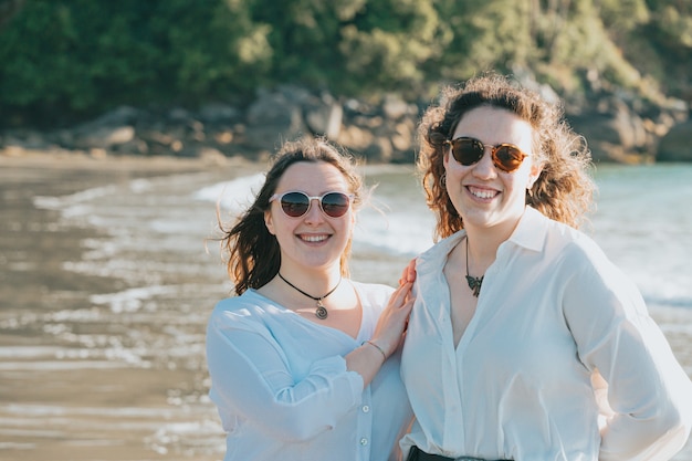 Joyeuses jeunes femmes riant et souriant à la plage un jour d'été, profitant de vacances, concept d'amitié profitant de l'extérieur