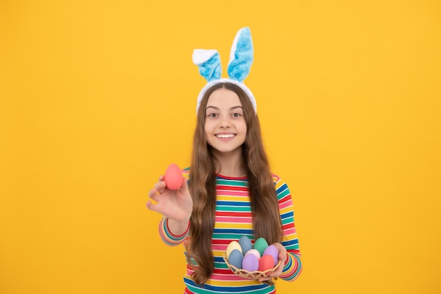 Joyeuses pâques adolescente dans des oreilles de lapin lapin tenant des oeufs peints pour les vacances chasse aux oeufs vacances de pâques