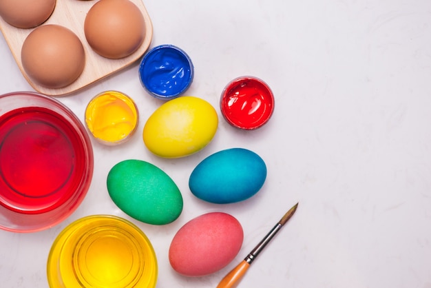 Joyeuses Pâques! Amis peignant des oeufs de Pâques sur la table.