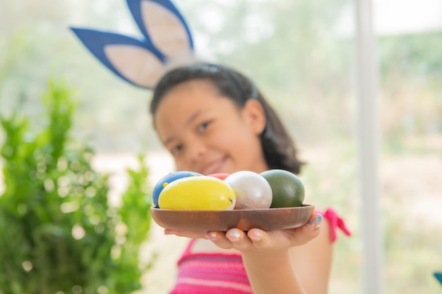 Joyeuses pâques Une belle enfant fille peignant des oeufs de pâques famille heureuse se préparant pour pâques mignonne petite fille enfant portant des oreilles de lapin le jour de pâques