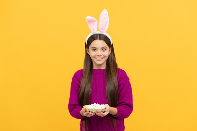 Joyeuses pâques bonheur de l'enfance enfant en costume de lapin tenir des oeufs peints de caille temps pour la chasse aux oeufs adorable enfant portant des oreilles de lièvre drôles vacances de printemps de pâques heureuse adolescente porter des oreilles de lapin