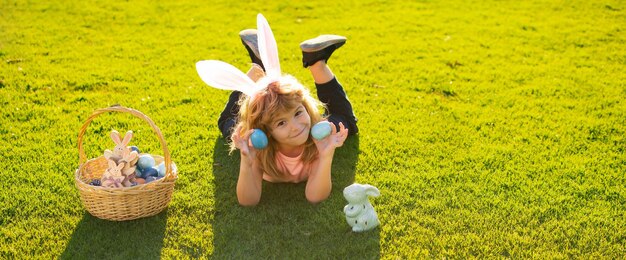 Joyeuses pâques enfants célébrant l'enfant de pâques en costume de lapin avec des oreilles de lapin en plein air