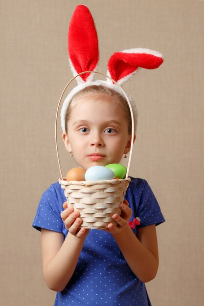 Joyeuses Pâques. Fille enfant avec des oreilles de lapin et des œufs.