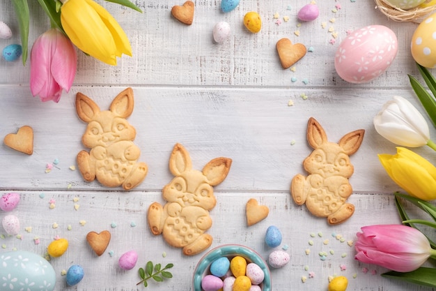 Joyeuses pâques fond avec lapins oeufs bonbons fleurs